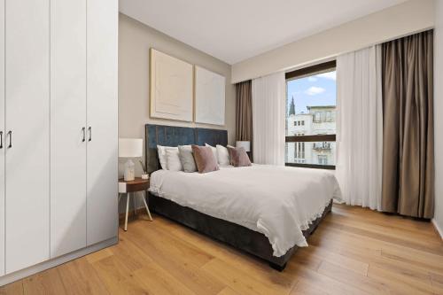 a bedroom with a large bed and a window at King David Apartment - J&J in Jerusalem