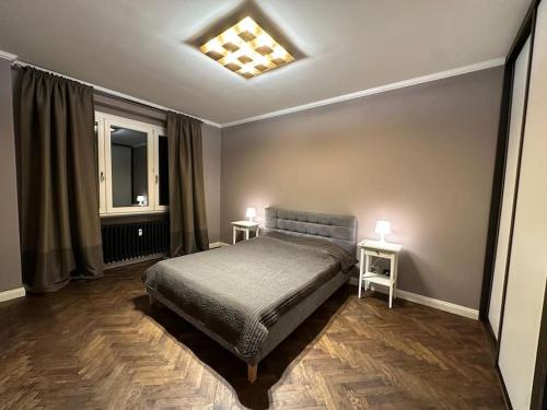 ein Schlafzimmer mit einem Bett und zwei Tischen mit Lampen in der Unterkunft Fancy flat in central Bratislava in Bratislava