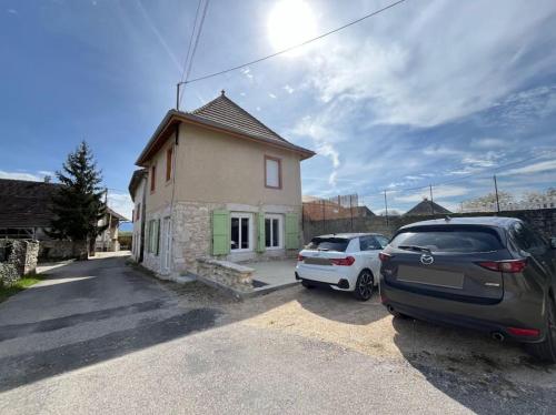 two cars parked in a parking lot in front of a house at La Maison L’oiseau Bleu in Saint-Victor-de-Morestel