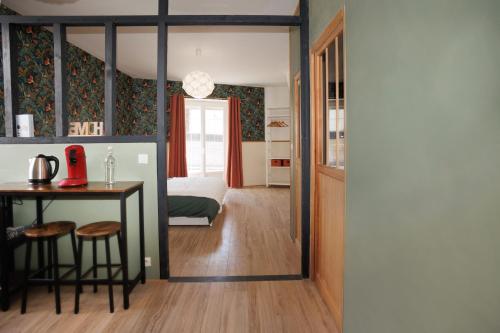um quarto com uma cama, uma mesa e uma secretária em Maison du Bien-être em Yvré-le-Pôlin