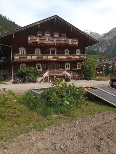 a large wooden building with a ramp in front of it at Obenfigerhof in Kals am Großglockner