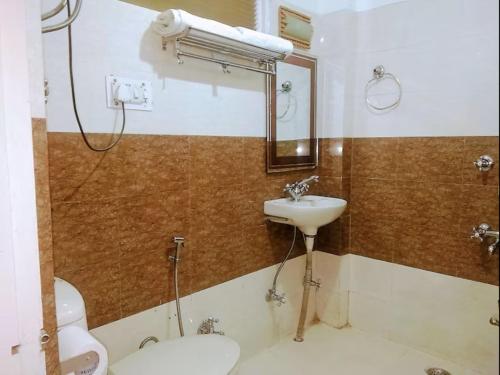 uma casa de banho com um lavatório, um WC e um espelho. em Star Rising em Manali