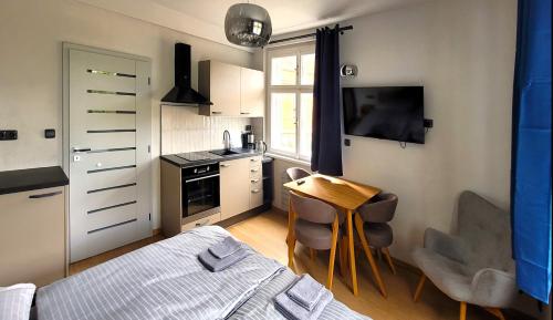 a small kitchen with a bed and a table with chairs at Bunkr Karlštejn in Karlštejn