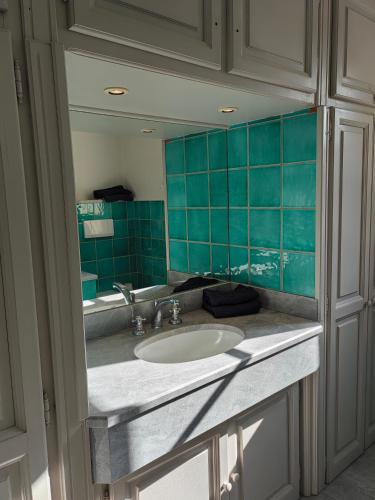 un comptoir de salle de bain avec un lavabo et un miroir dans l'établissement villacoucourelle saintemaximecom quiet near beach & center with sea and garden views, à La Garonnette-Plage