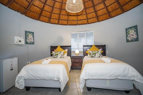 a bedroom with two beds and a ceiling at 19th Hut in Pretoria