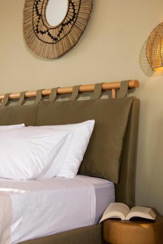 a bedroom with a bed with a book on it at Lithorama Residence Mani Complex in Koúmani