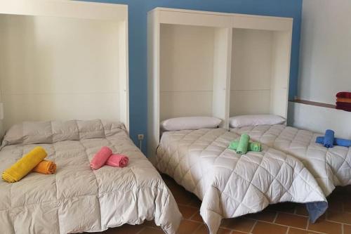 two beds with colorful pillows on them in a room at Villa Marichu. Piscina, BBQ y a 15 min Puy du Fou in Totanés