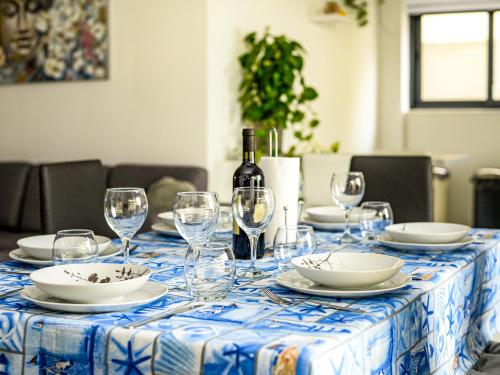 uma mesa com copos e pratos e uma garrafa de vinho em Seaview-CasadiAlfio-Qawra em St. Paul's Bay