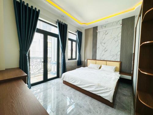 a bedroom with a bed and large windows at TONY HOMESTAY CẦN THƠ in Can Tho