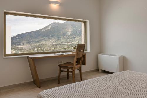 a bedroom with a desk with a view of a mountain at Villa Templin in Chaliotata