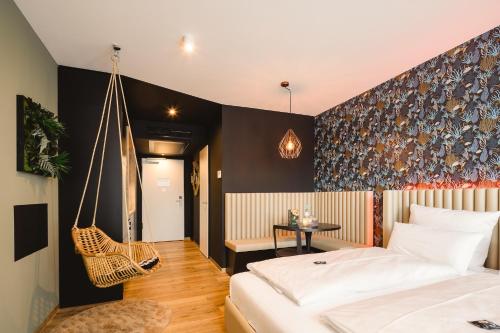 sypialnia z łóżkiem i wiszącym krzesłem w obiekcie Rioca Konstanz Posto 10 w Konstancji