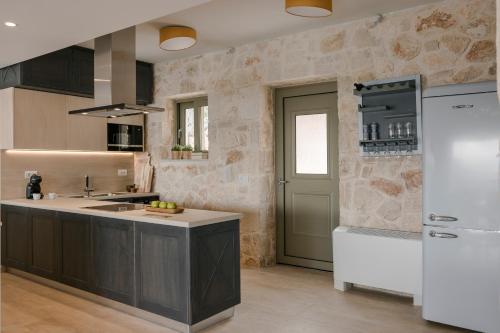 a kitchen with a white refrigerator and a sink at Villa Templin in Chaliotata