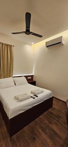 a bedroom with a bed with a ceiling fan at Chippy Inn in Chennai