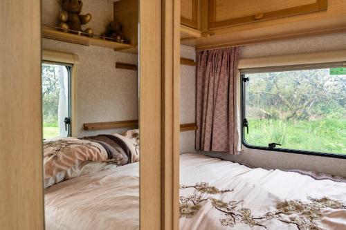 um quarto com uma cama e uma janela em Canvas & Cabins - Orchard View em Germansweek