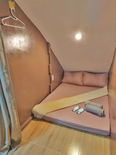 ein kleines Bett in einem winzigen Haus mit zwei Kissen in der Unterkunft Aashvi Cozy Cabin Hostel near Mactan Airport in Pusok