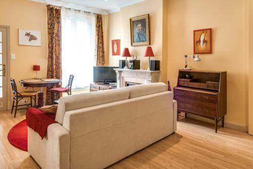 un salon avec un canapé et une télévision dans l'établissement Studio Montorgueil - Welkeys, à Paris