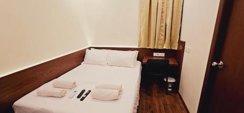 a small bedroom with a bed with two towels on it at Chippy Inn in Chennai