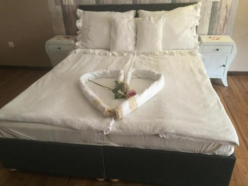 a bed with a heart made out of pillows at Guest House Romantika Panzio in Gyula