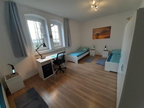 a room with two beds and a desk in a room at Spacious Apartment for Traveler and Fitter in Lollar
