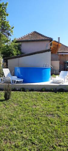 a group of chairs and a blue and white pool at Fortuna Vendégház in Egerszalók