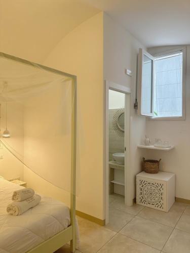 a bedroom with a bed and a bathroom with a window at Palmieri Luxury Rooms in Gallipoli