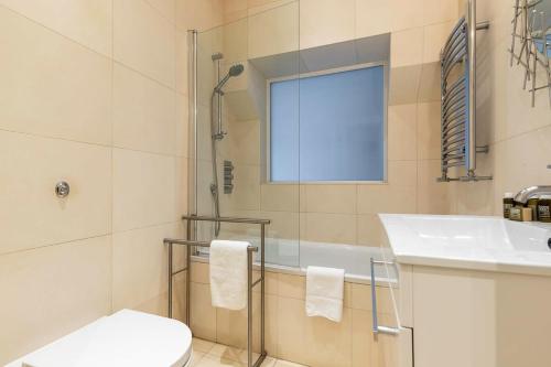 a bathroom with a shower and a sink and a toilet at Urban Living - 2Bed 2Bath in South Kensington in London