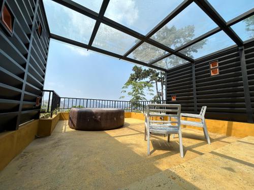 a patio with a white chair and a bench at Maram Resort Mamalakandam in Mamalakandam