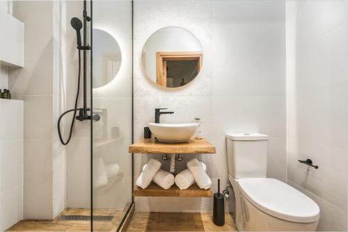 een badkamer met een wastafel, een toilet en een spiegel bij Aggeliki Studios in Laganas