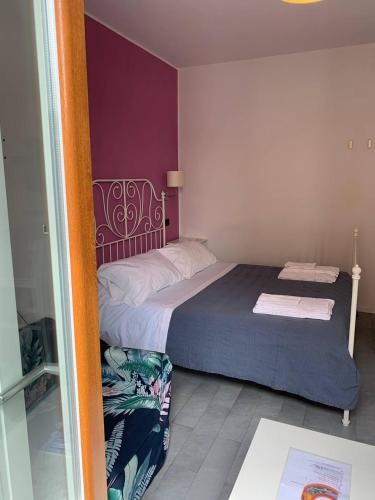 a bedroom with a bed and a purple wall at Guest house Le Sibille in Taormina
