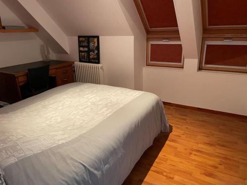 une chambre avec un lit, un bureau et des fenêtres dans l'établissement Grande maison à louer pour les 24h et autres dates, au Mans