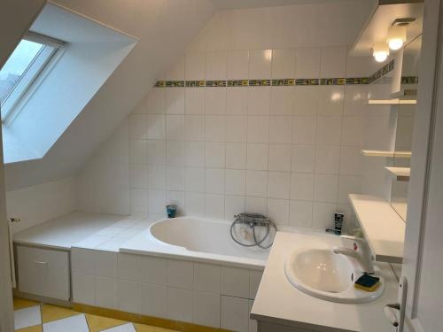 une salle de bain blanche avec une baignoire et un lavabo dans l'établissement Grande maison à louer pour les 24h et autres dates, au Mans