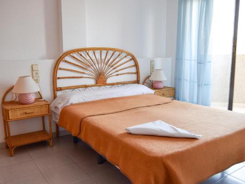 1 dormitorio con 1 cama grande y 2 mesitas de noche en Apartamentos Olimpo 3000, en Peñíscola