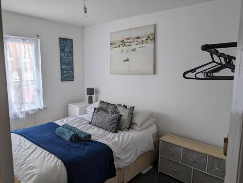 a bedroom with a bed with a blue blanket on it at Beautiful 3-Bed Apartment in Hythe High Street in Hythe