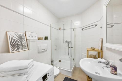 a white bathroom with a shower and a sink at Casa Tucan ~ Hemsbach in Hemsbach
