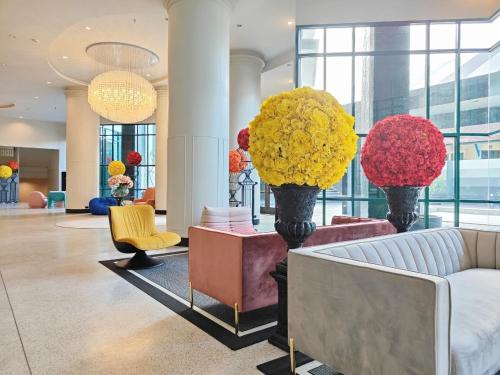 a lobby with couches and flowers in a building at Solis Beach Hotel Rajamangala in Songkhla