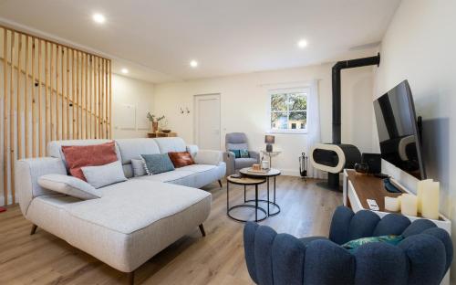 a living room with two couches and a tv at Descanso das Palmeiras - HOST & CHILL in Furnas