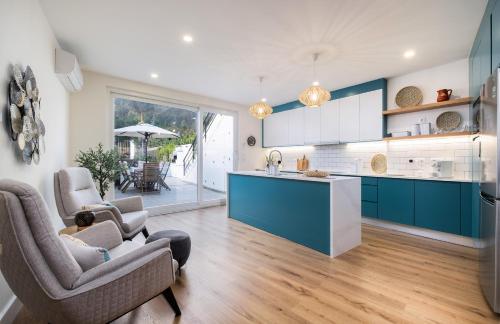 a kitchen and living room with blue cabinets at Descanso das Palmeiras - HOST & CHILL in Furnas