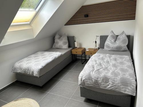 a bedroom with two beds and a window at Ferienwohnungen Im Kimmelreich in Irsch