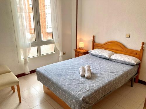 Un dormitorio con una cama con un animal de peluche encima. en Apartamento SomoMar, en Somo
