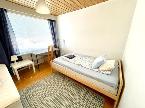 a bedroom with a bed and a desk and a window at Simunakankaantie, Pyhäjoki in Pyhäjoki