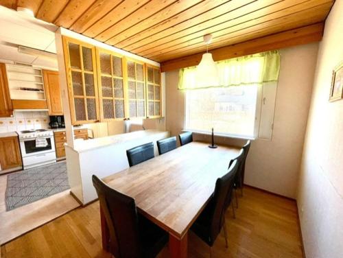 a kitchen with a large wooden table and chairs at Simunakankaantie, Pyhäjoki in Pyhäjoki