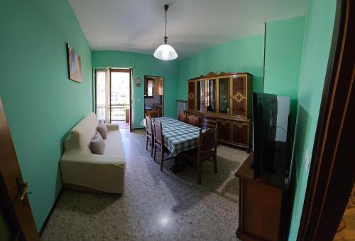 sala de estar con sofá, mesa y TV en Appartamento b&b 'Casa Vittoria' en SantʼAntonino di Susa