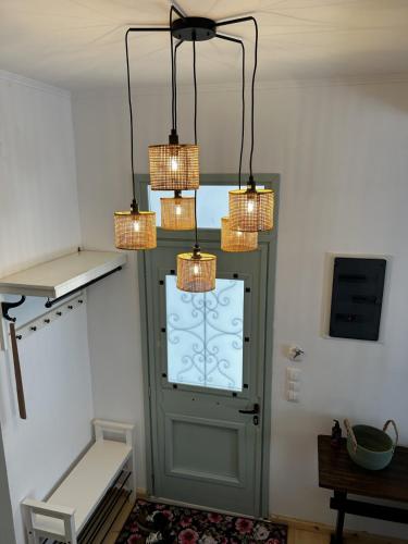 a room with a green door and three chandeliers at Homefeel2024 in Kavála