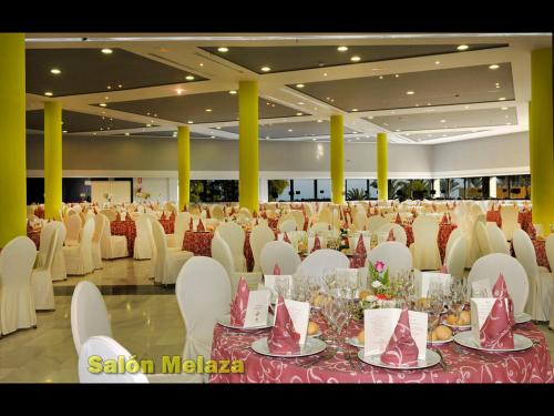 a large banquet hall with white chairs and tables at Hotel Salobreña Suites in Salobreña