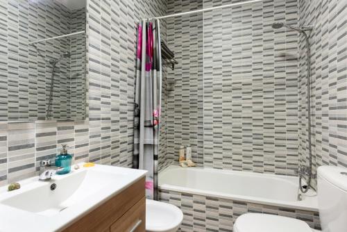 un bagno con lavandino, WC e vasca di Suite Jinetes a Málaga