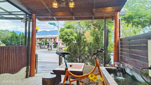 a bike parked under a pavilion next to a bench at Jinge Guest House 集集金格民宿電動車充電站 in Jiji