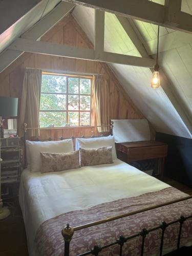 a bedroom with a large bed in a attic at Highlands Farm Cottage in Van Reenen