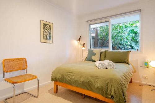 a bedroom with a bed with a window and a chair at Frankston South Beachside Gem in Frankston South