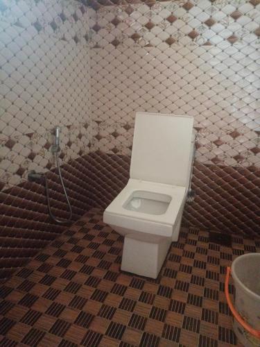 a bathroom with a toilet in a tiled wall at Coco on the Cliff in Thottada