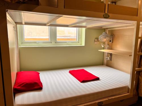 a bunk bed with two red pillows on it at Hanoi EcoStay 1 hostel in Hanoi